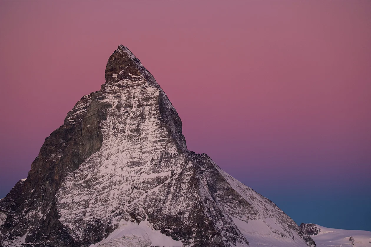 Le Cervin enneigé sous un ciel rose et bleu au coucher de soleil