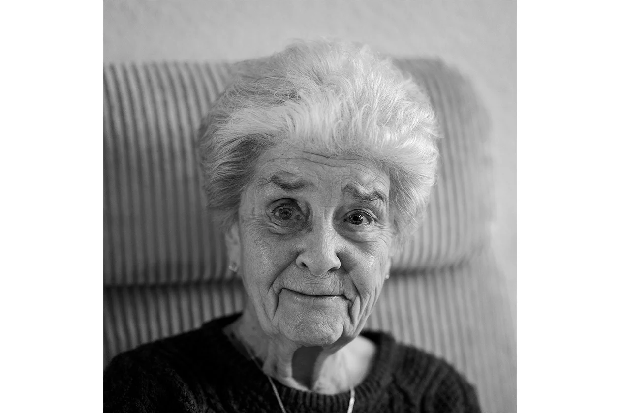 Portrait noir et blanc d'une femme âgée aux cheveux blancs, regard doux et lumineux