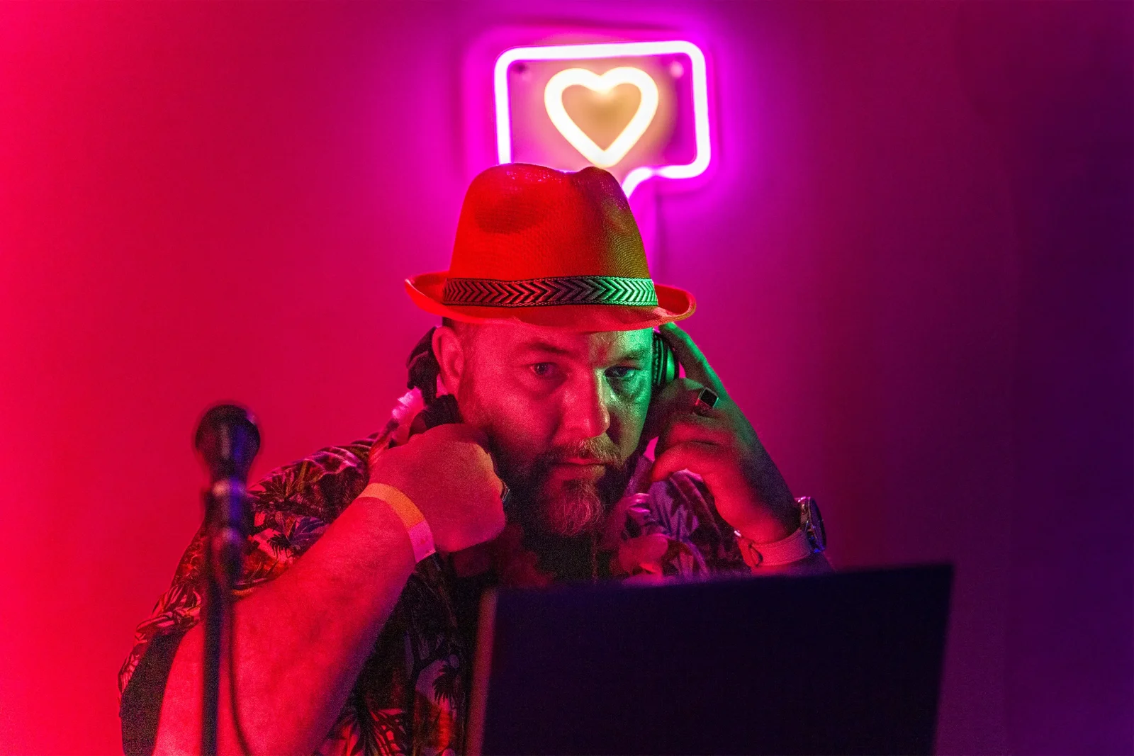 Thomas, DJ en performance sous des néons rouges et roses — portrait sur mesure par Yann Lepora