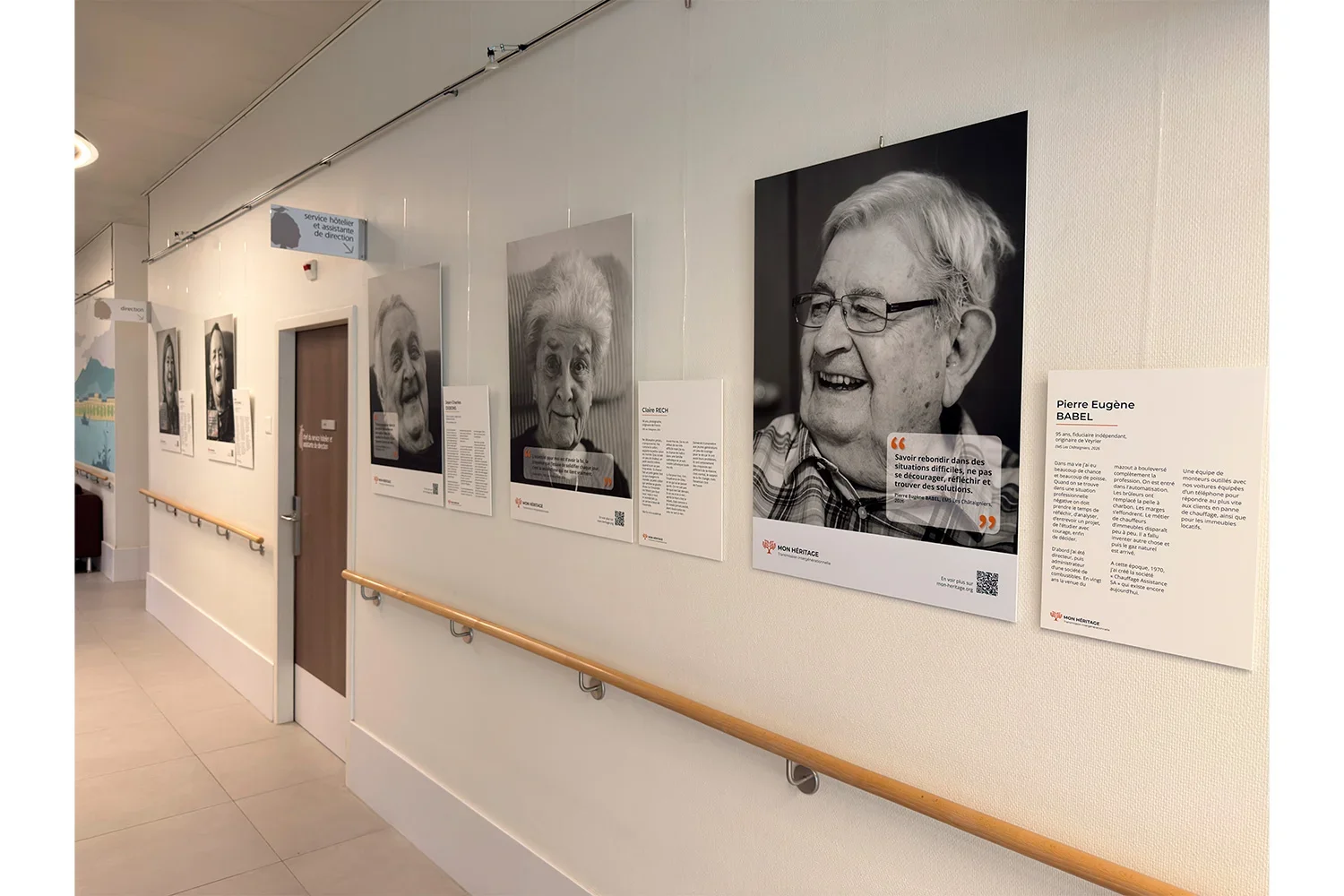 Exposition Mon Héritage : portraits intergénérationnels accrochés dans un couloir d'un EMS